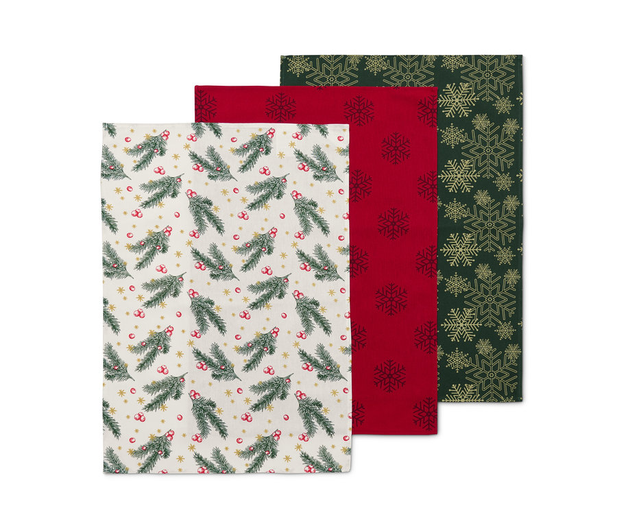 Három konyharuha: egy fenyőág mintával, egy piros hópehely mintával, egy zöld arany hópehely mintával.