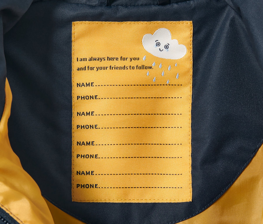 A Kisgyerek esőoverál belseje név és telefonszám címkével.