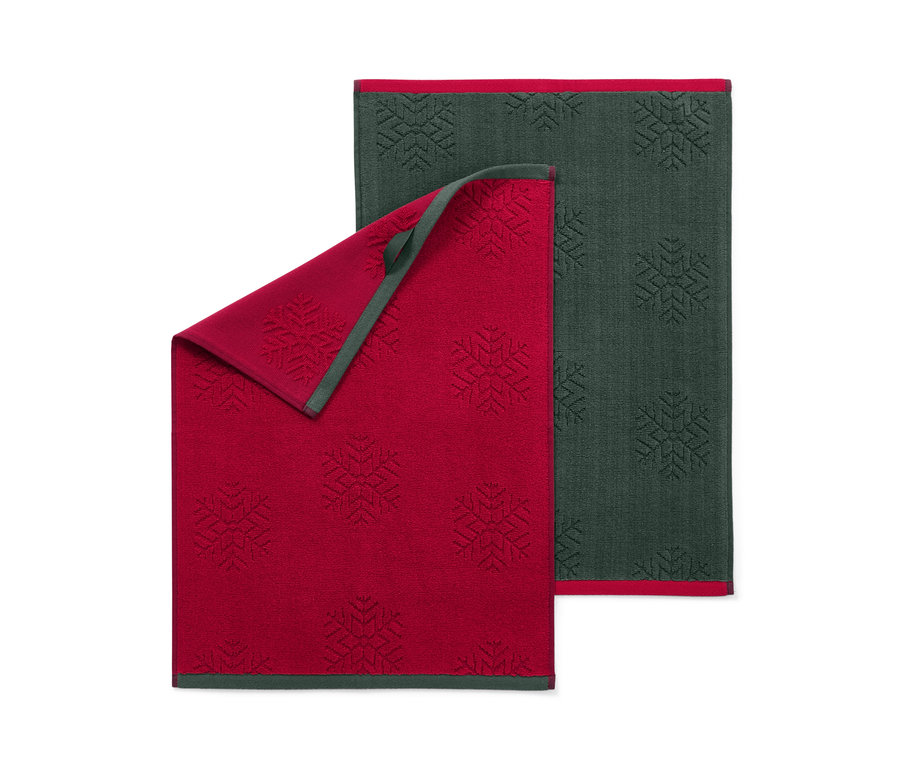 Két konyhai kéztörlő hópehely mintával, egy piros és egy sötétzöld.
