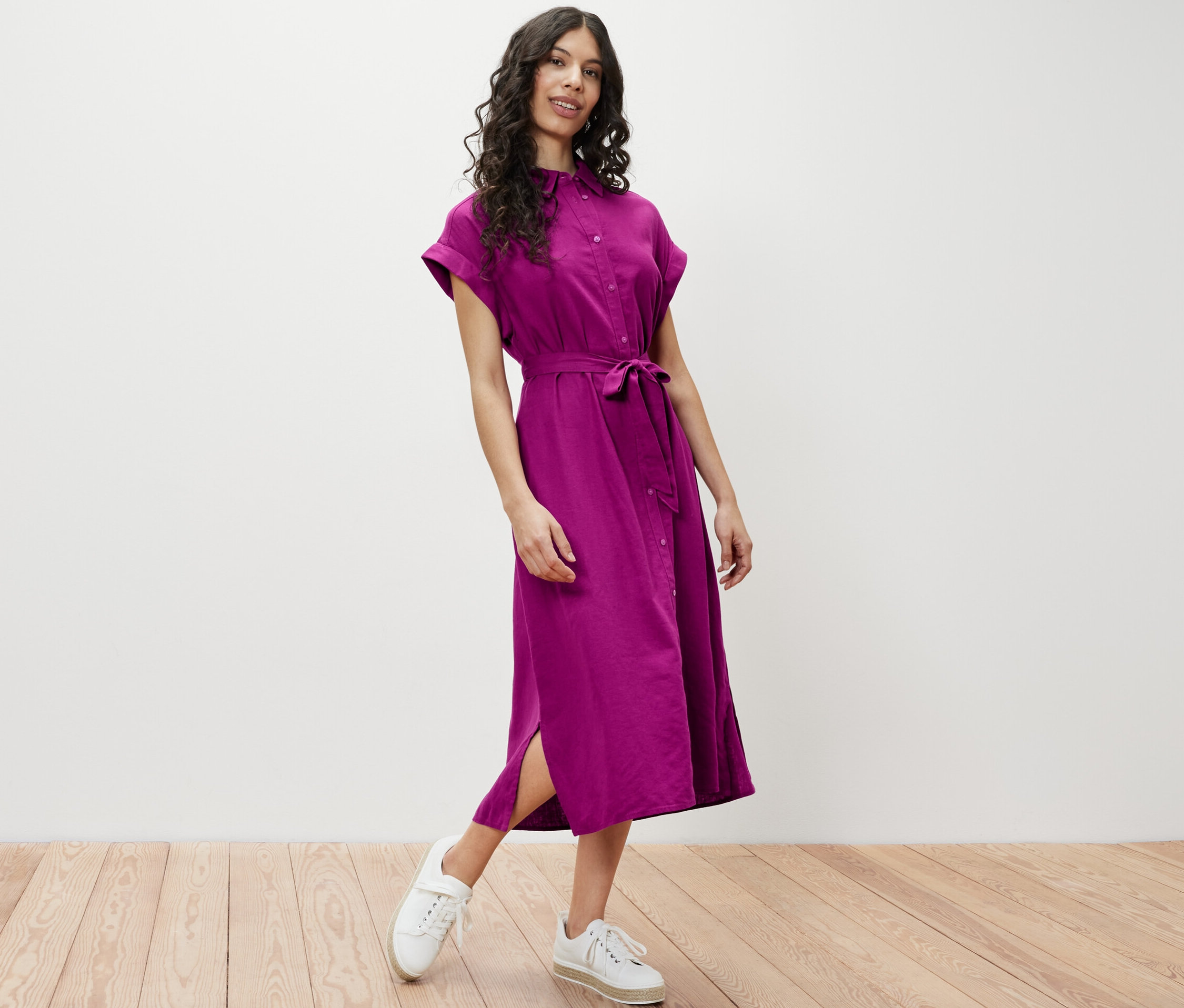 Nő pózol egy lenvászon blúzruhában.