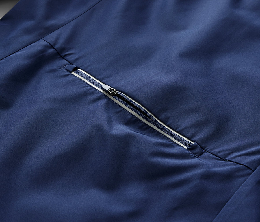 Egy kék, 2 az 1-ben kerékpáros kabát részlete cipzárral.