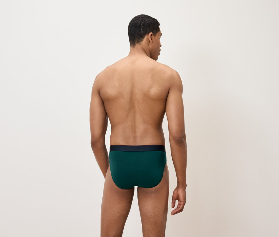 Egy férfi háttal a kamerának zöld alsónadrágot visel.