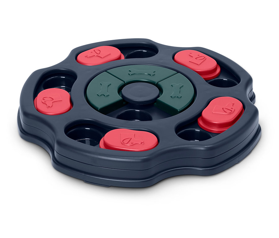 Interaktív kutyajáték forgó mechanizmussal, piros fedőkkel és zöld csontokkal.