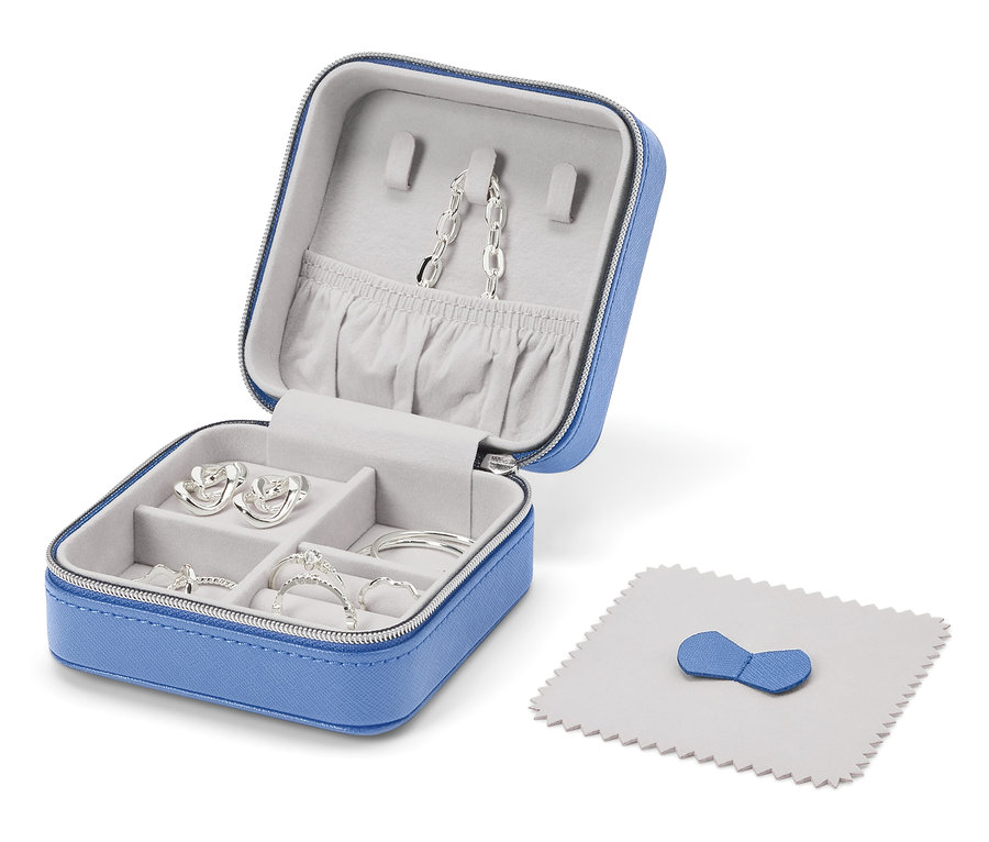 Nyitott kék ékszerdoboz ezüst ékszerekkel és polírozó kendővel.