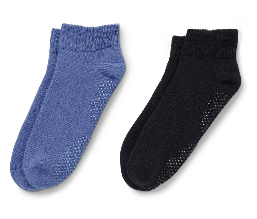 Két pár zokni, egy kék, egy fekete pár fekszik fehér háttéren.