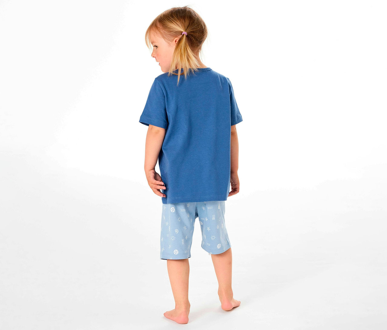 Hátulról látható egy kislány SCHIESSER rövidnadrágos gyerekpizsamában.