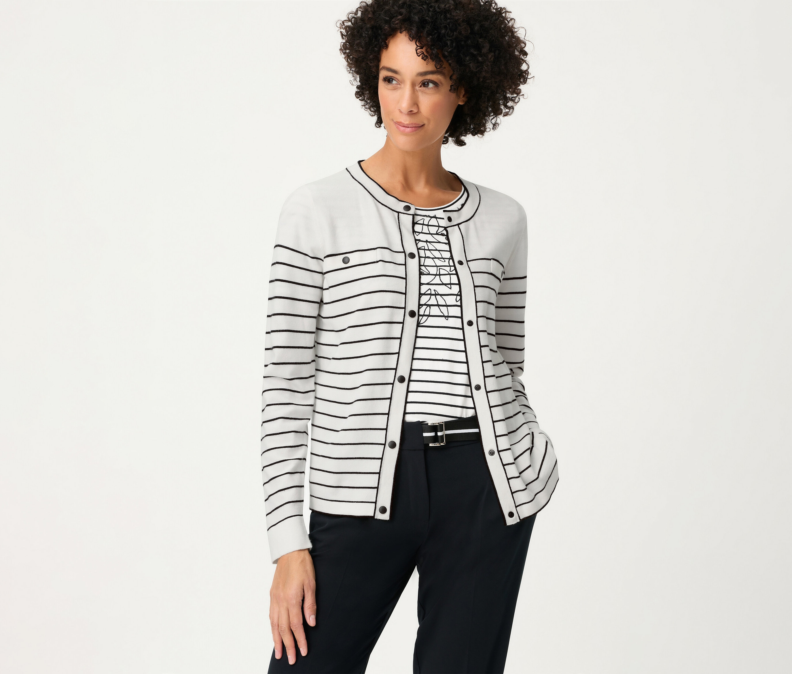 Nő csíkos felsőben és Olsen »LA« kardigánban. Sötét nadrágot visel övvel.