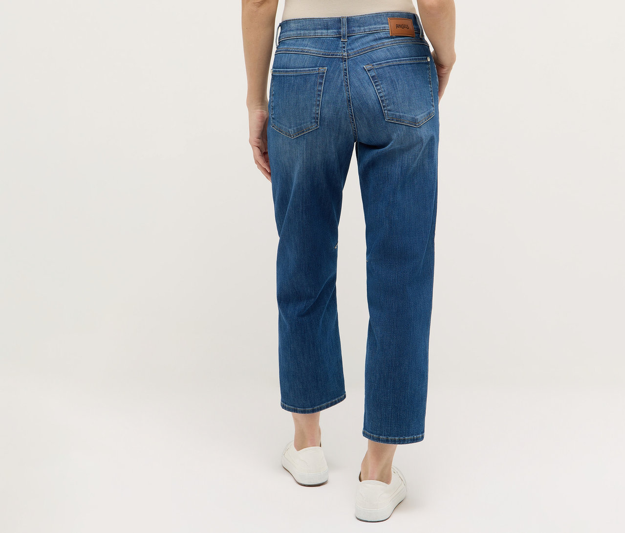 Hátulnézet egy nőről, aki kék Angels denim »Evi« farmert és fehér cipőt visel.