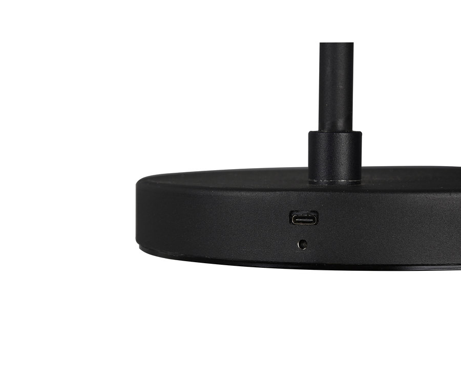 Közelkép egy matt fekete lámpatalpról, USB-C porttal és egy kis kerek jelzőfénnyel.