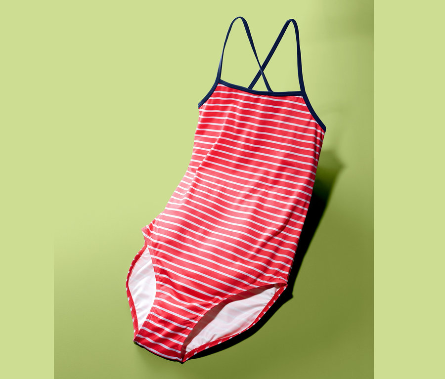 Piros-fehér csíkos, sötétkék pántos lány fürdőruha zöld háttérrel.
