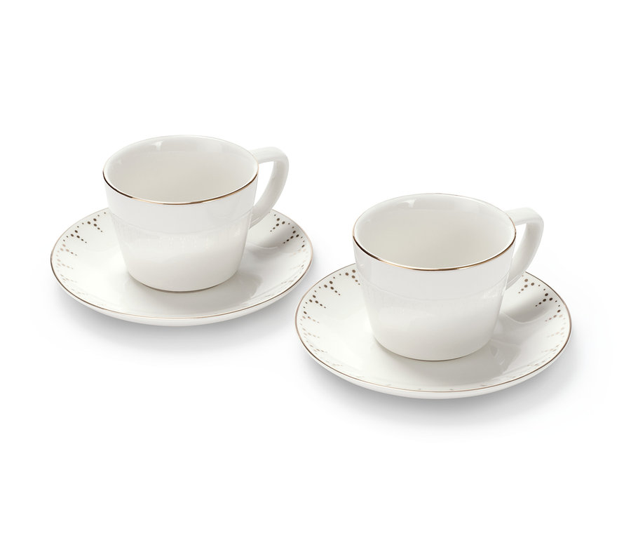Két csésze a 2 darabos, arany mintás porcelán kávéscsésze készletből alátétekkel, fehér háttér előtt.