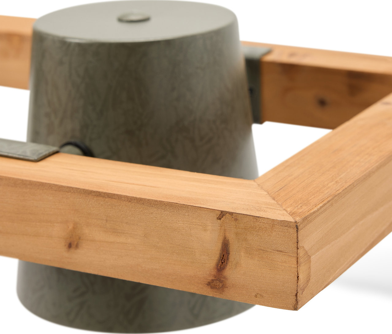 Egy szürke karácsonyfatalp részlete fa kerettel.