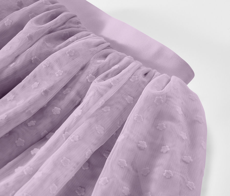 Közeli kép egy ráncolt, levendula színű tüllszövetről, pöttyös mintával.