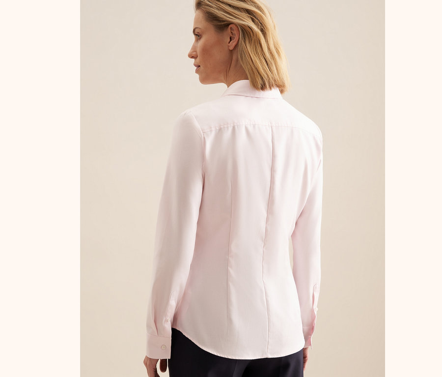 Nő visel egy rózsaszínű Seidensticker twill blúzt.