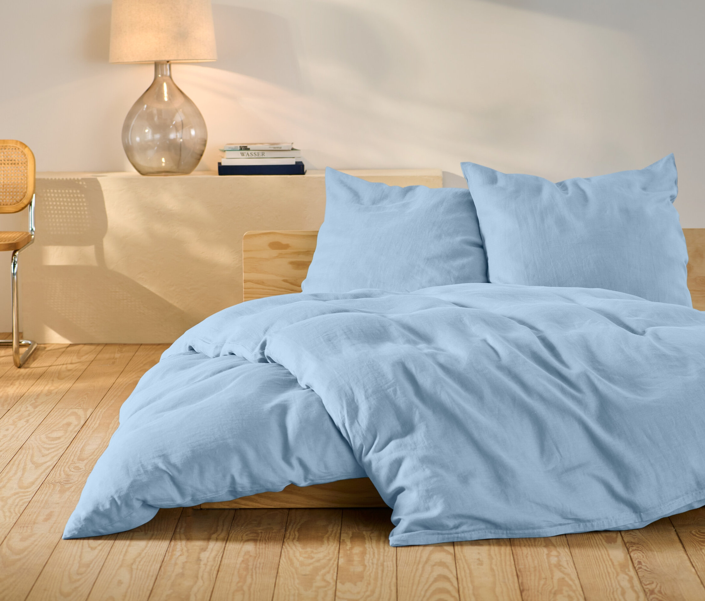 Világoskék, standard méretű ágyneműhuzat egy ágyon.