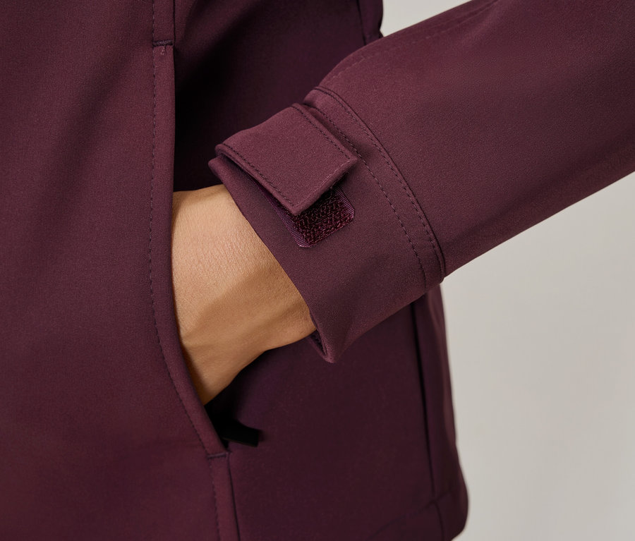 Egy kéz egy bordó kabát zsebében, részletek, mint egy tépőzáras mandzsetta.