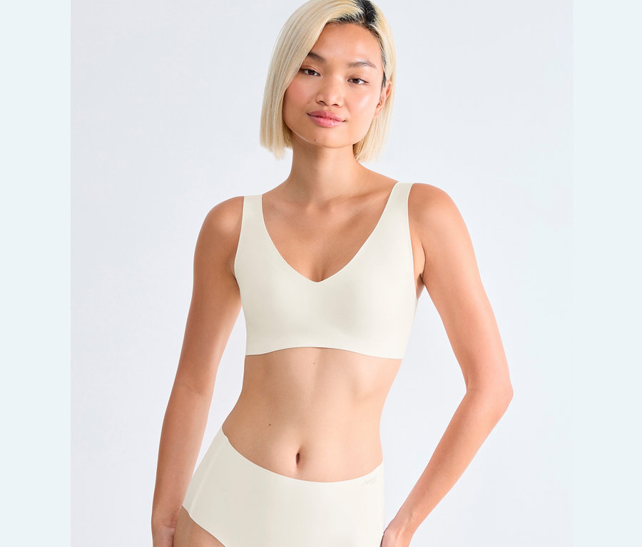 Nő visel egy selyemfehér sloggi ZERO Feel 2.0 melltartót.