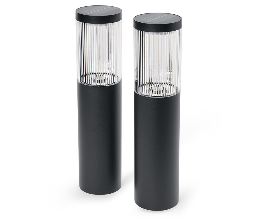 Két fekete szolárlámpa áll fehér háttér előtt.