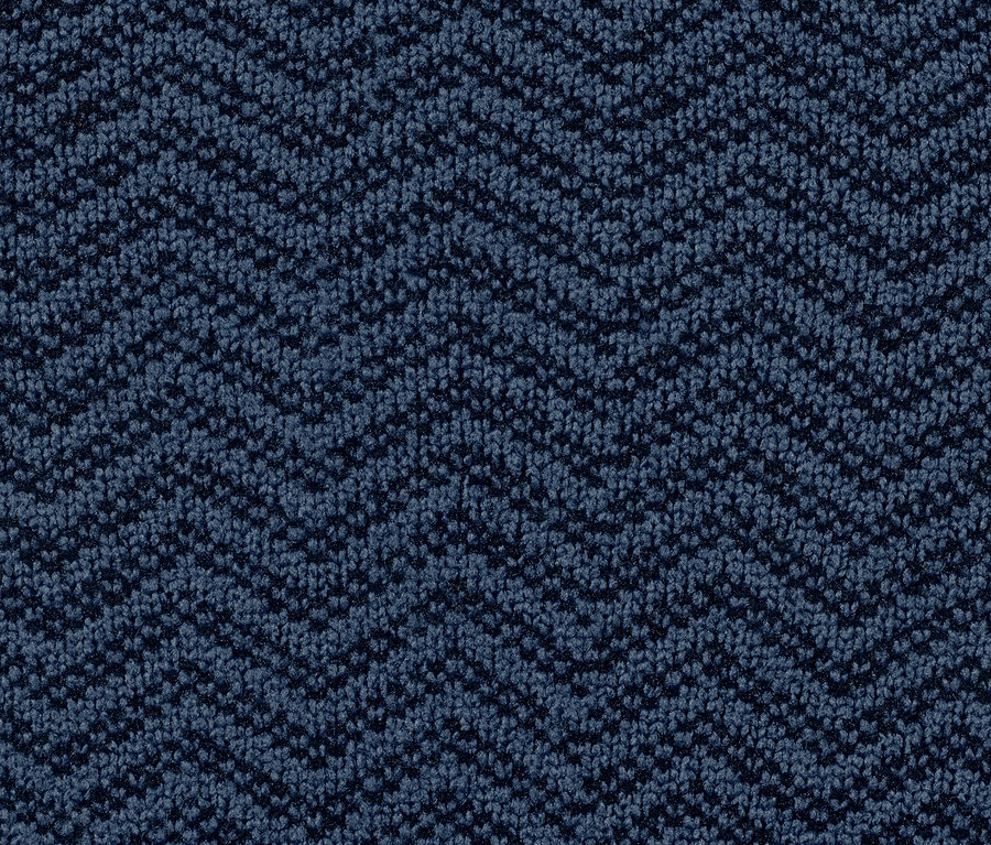 Egy kék, cikcakkos mintázatú szőnyeg közeli képe.