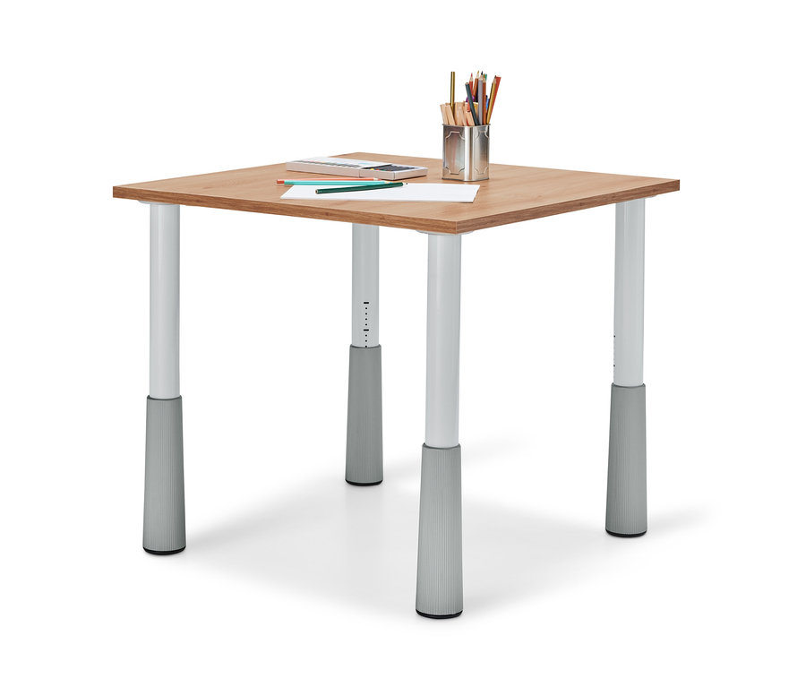 Egy állítható magasságú gyerekasztal négy lábbal, rajta egy papírlap, színes ceruzák és egy ceruzatartó.