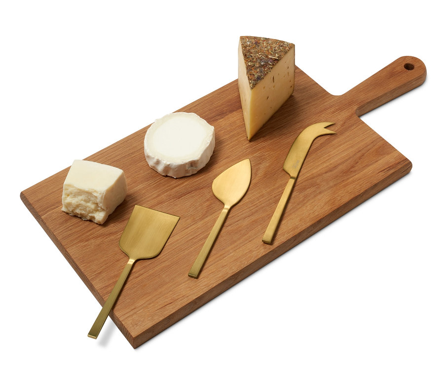 Fából készült deszka sajtokkal és sajtkés készlettel.