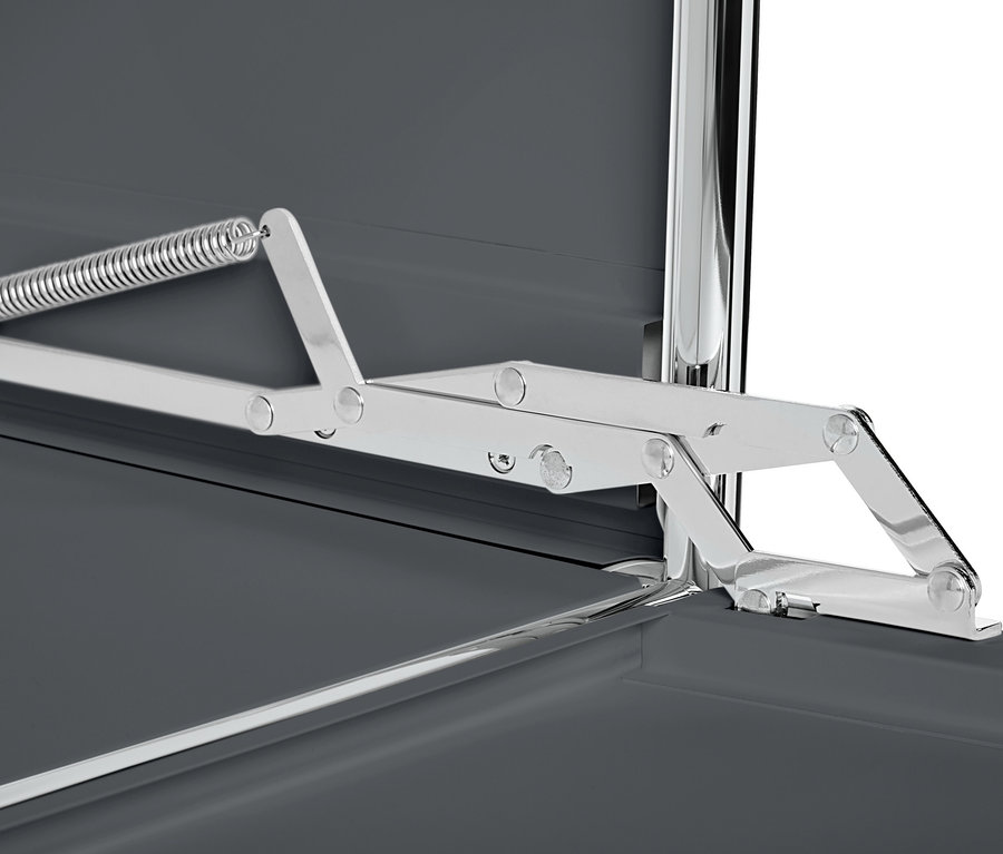 A szürke, fém komód (CN3) részlete, felnyíló ajtókkal és ezüst színű mechanizmussal.