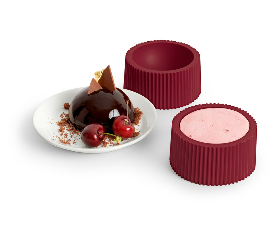 Csokoládé golyó cseresznyével tányéron, mellette 4 desszert forma.