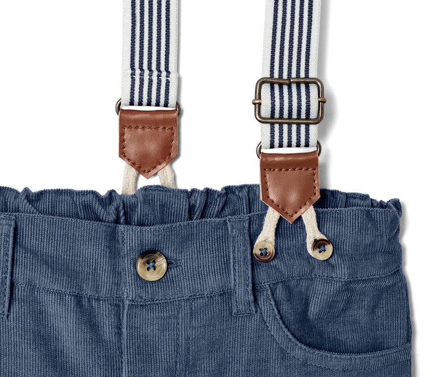 Egy kisfiú kordbársony kantáros nadrág részlete, gombolható zárással.