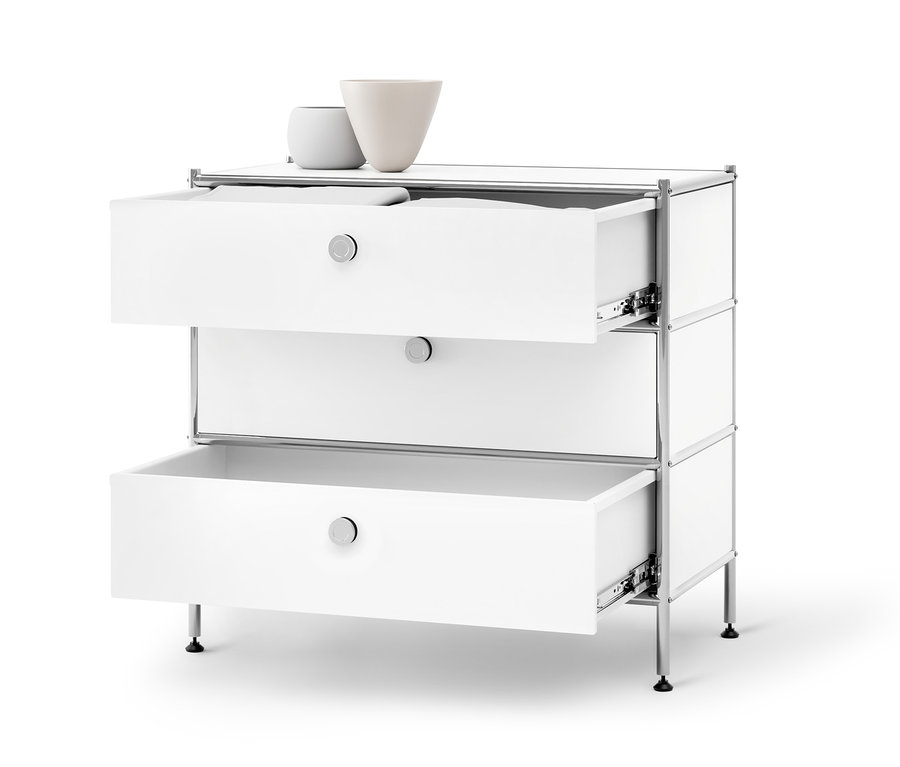Egy »CN3« fém komód 3 fiókkal, fehér színben, melyből kettő nyitva van, fehér háttér előtt.