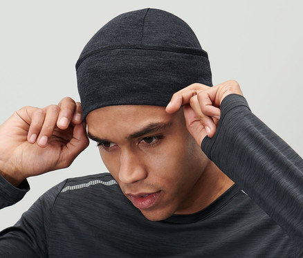 Férfi igazgatja a fején az antracit színű, merinói gyapjú sapkát.