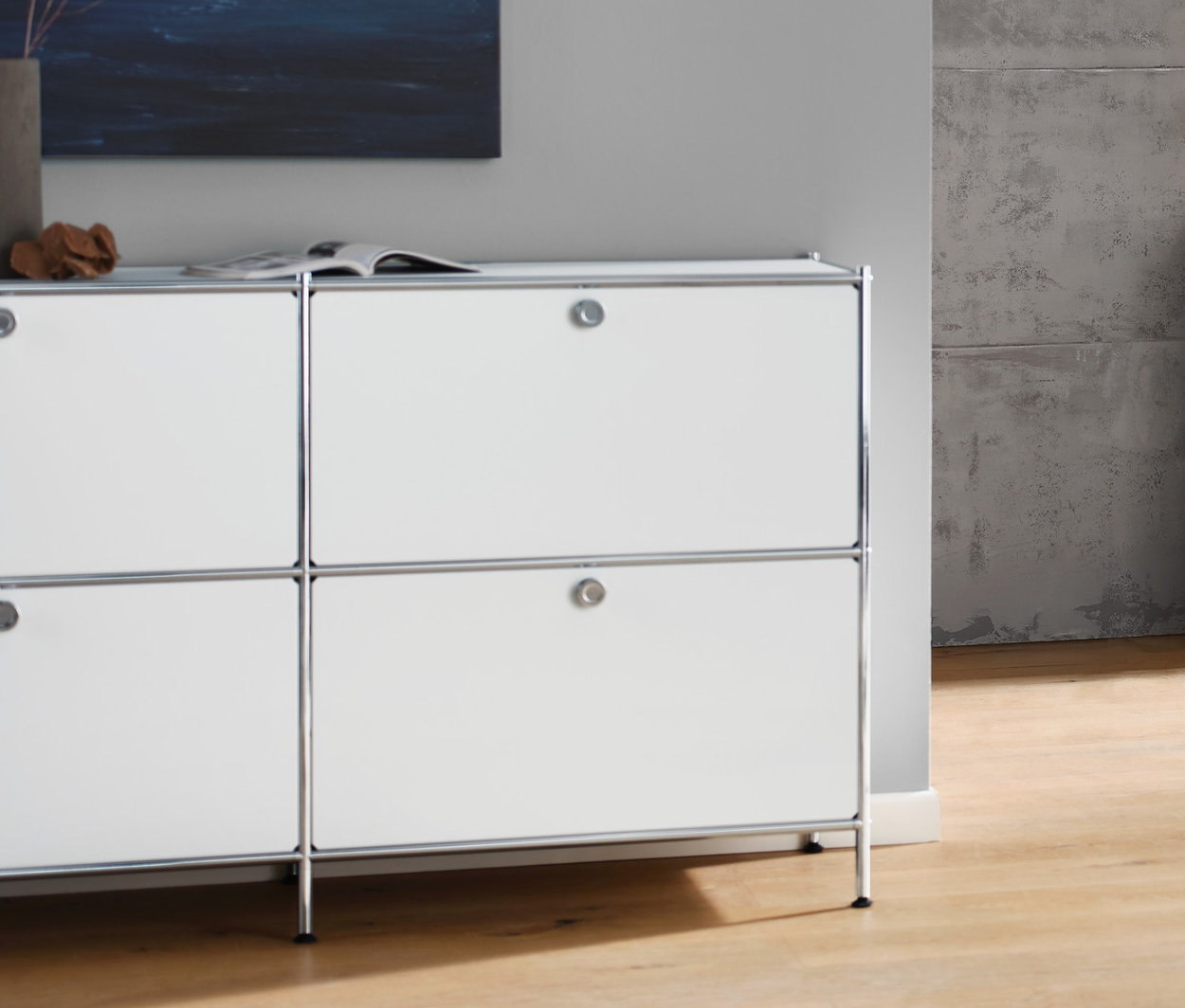 Nappali fehér »CN3« komóddal, 6 ajtóval, antracit 3 személyes kanapéval, fehér textilernyős asztali lámpával és fehér „CN3” dohányzóasztallal, görgőkkel.