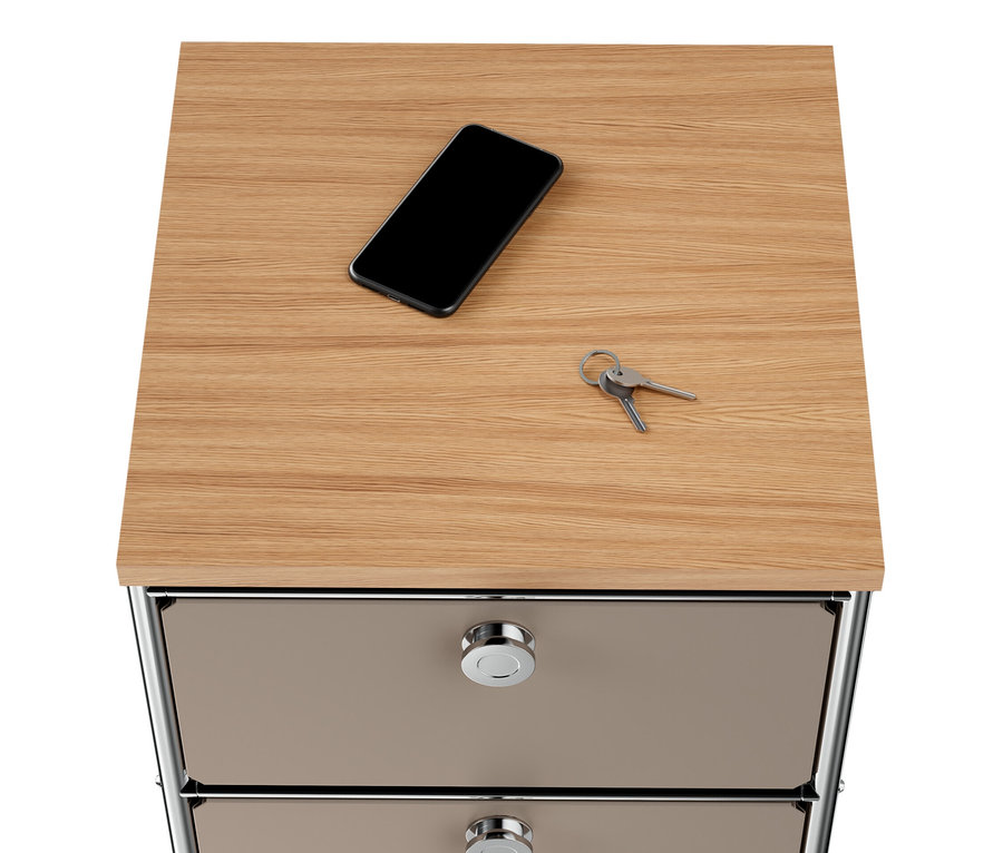 A szürkésbarna »CN3« keskeny fém komód fa tetején, 2 fiókkal, egy mobiltelefon és kulcsok találhatók.