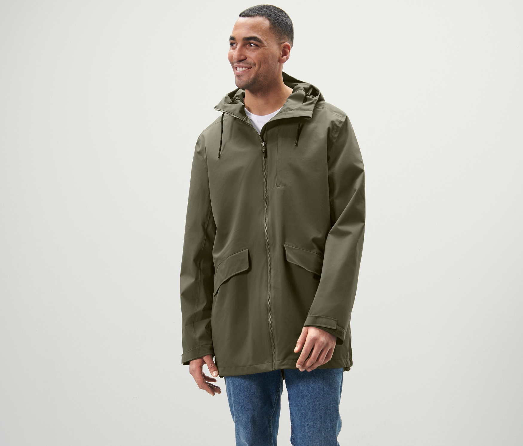 Egy férfi áll és outdoor funkcionális túradzsekit visel.