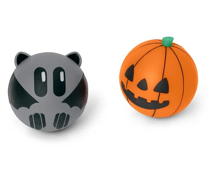 Két Halloween-i dekorációs labda: egy szürke denevér és egy narancssárga tök.