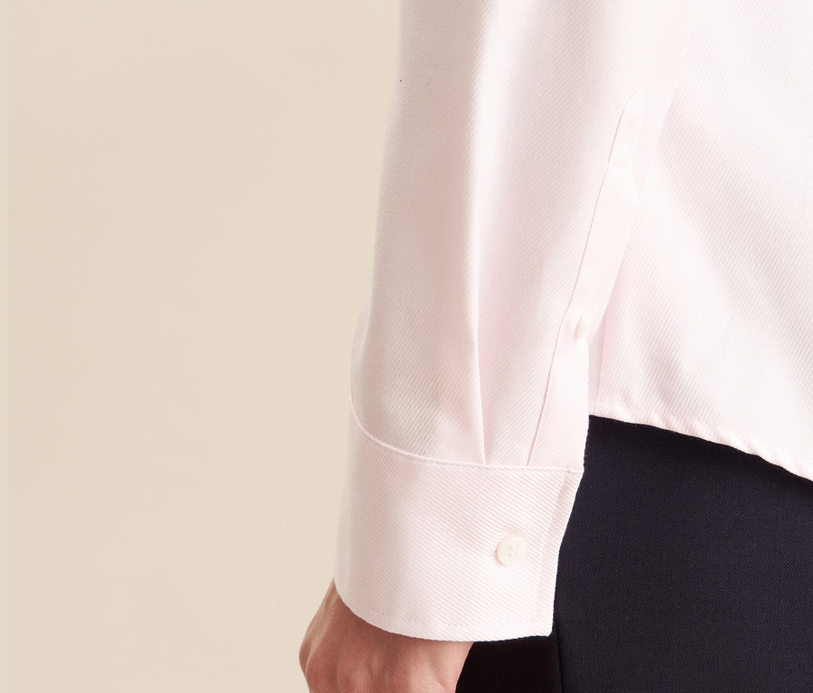 Egy rózsaszín Seidensticker twill blúz részlete egy nő karján.