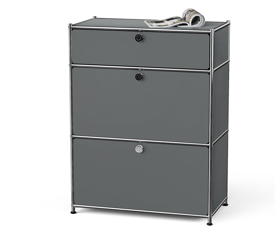 Szürke komód három fiókkal, króm kerettel és egy magazinnal a tetején.