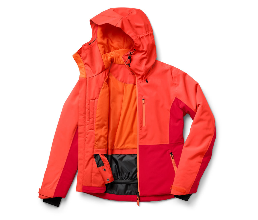 Egy nyitott, piros-narancssárga kapucnis kabát fekszik egy fehér háttéren.