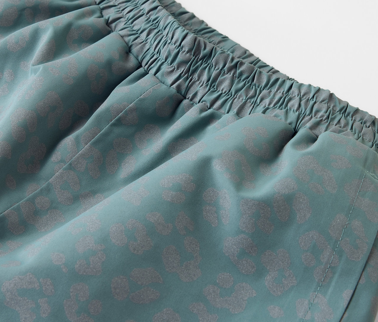 Közeli kép egy fényvisszaverő elemekkel ellátott gyerek esőnadrágról.