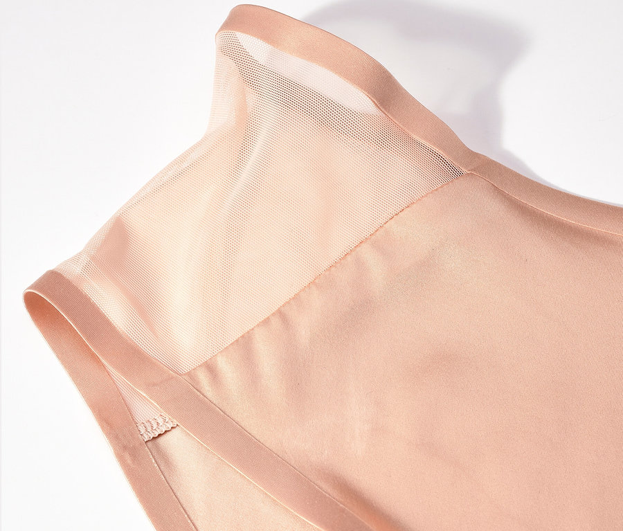 Közelkép egy bézs felsőről, átlátszó betéttel a vállán.