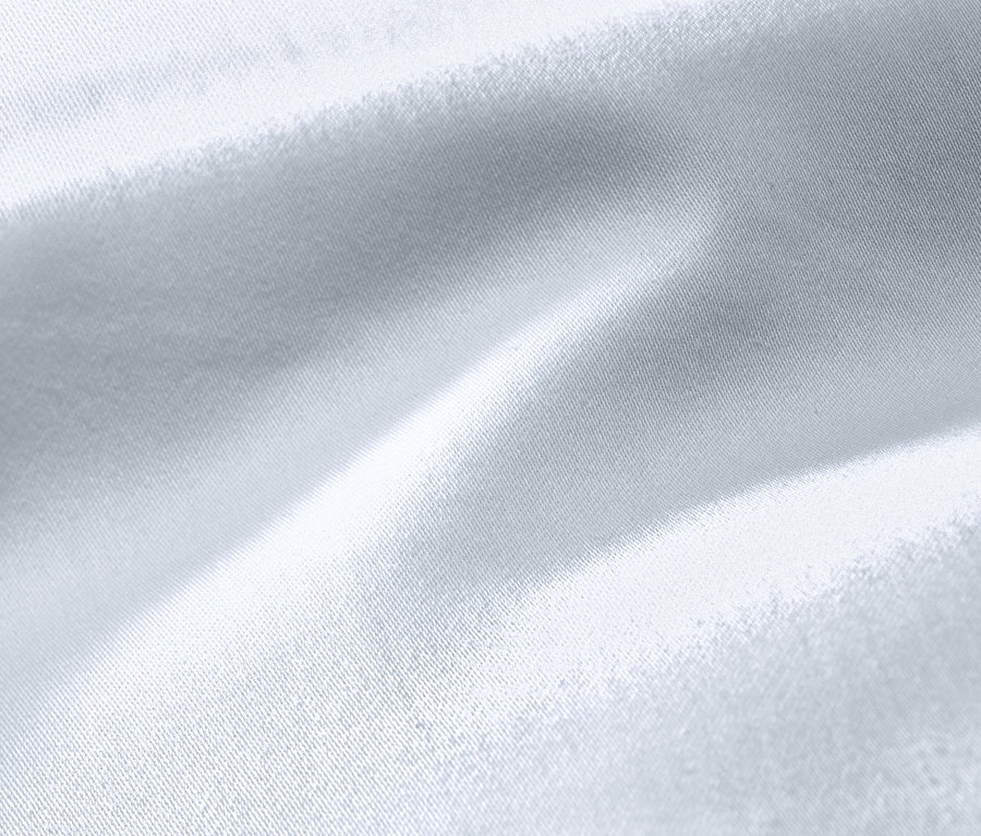 Nagyított kép egy fehér, extra méretű pamutszatén ágyneműről.