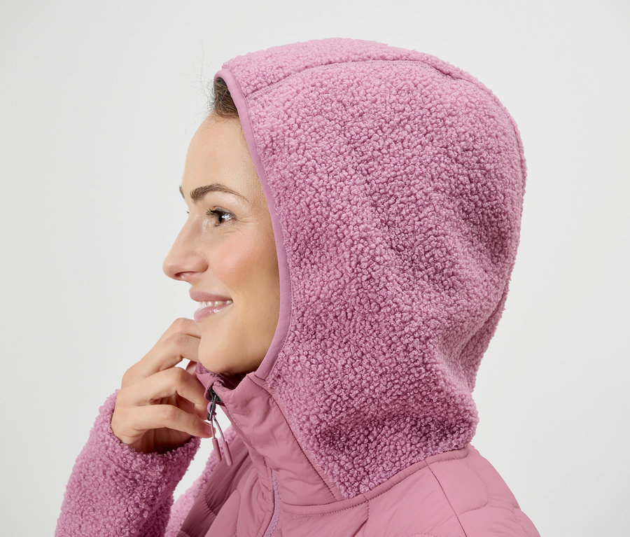 Nő rózsaszín kapucnis kabátban.