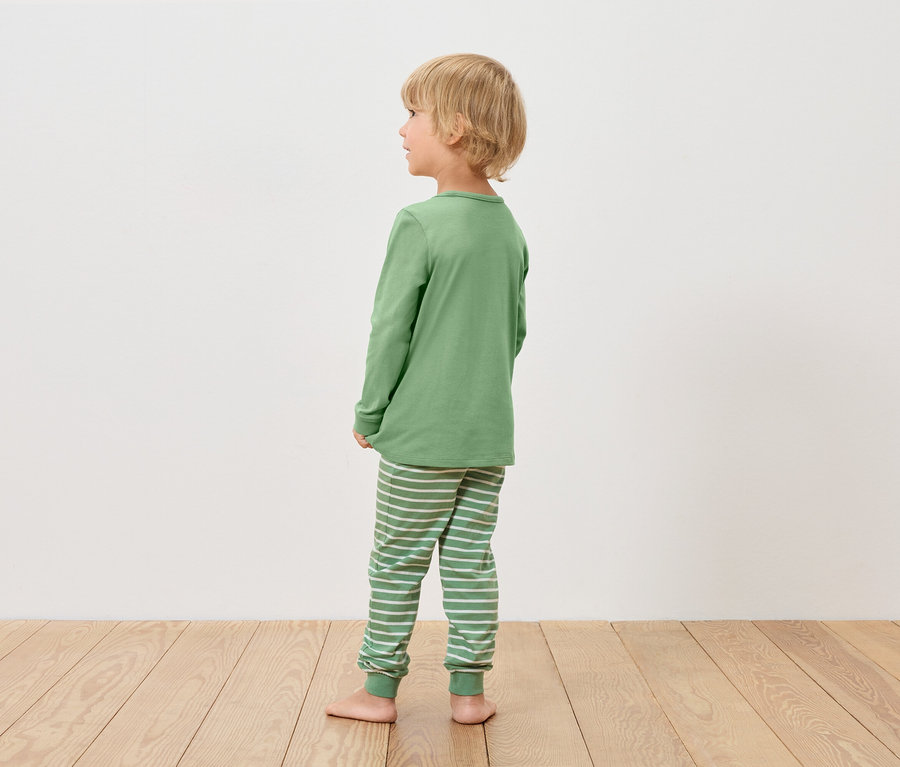 Fiú zöld pizsamában balra néz.