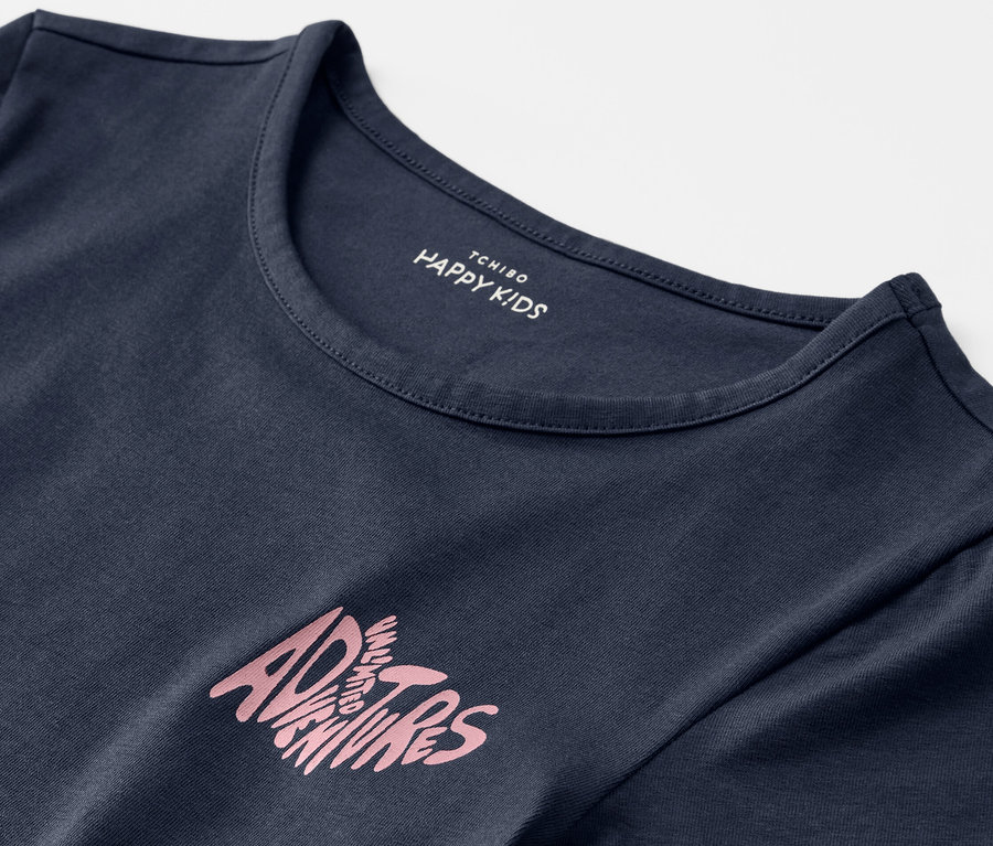 Kék gyerekpóló részlete, "Adventures" felirattal.