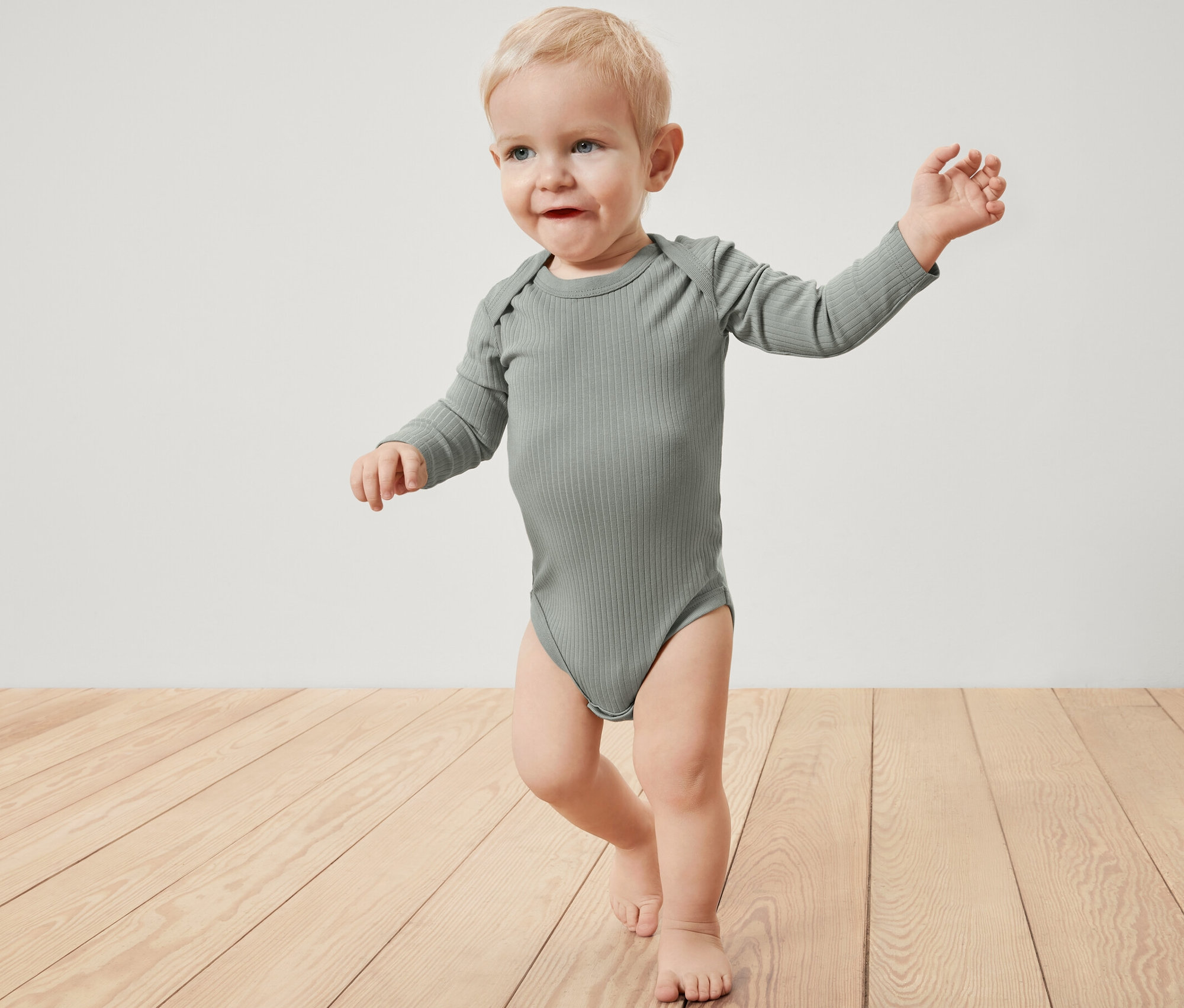 Kisgyermek bordás, hosszú ujjú bodyban.