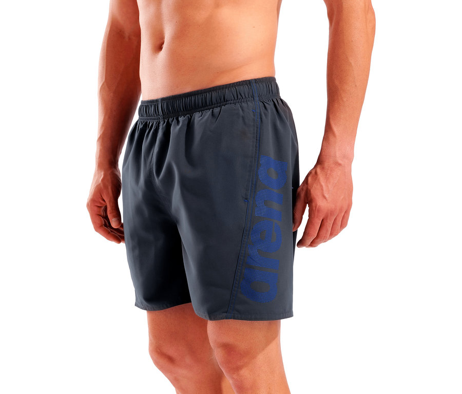 Férfi visel szürke úszónadrágot kék 'Arena' felirattal a lábán.