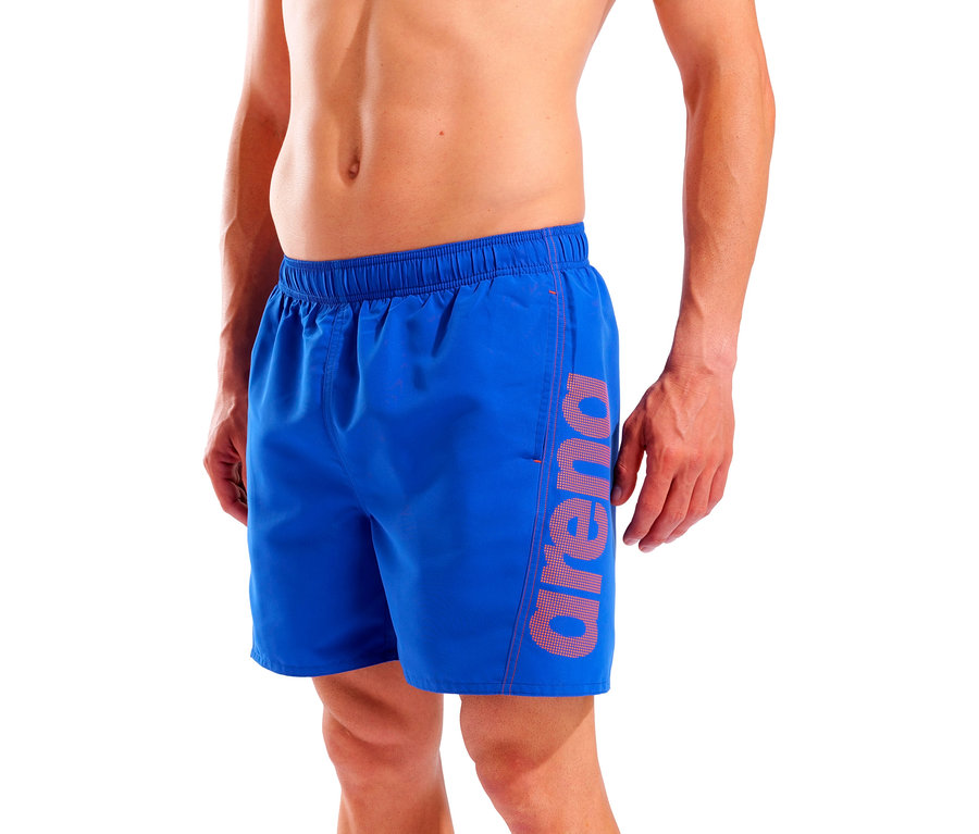 Férfi kék fürdőnadrágot visel, melynek szárán Arena logó található.