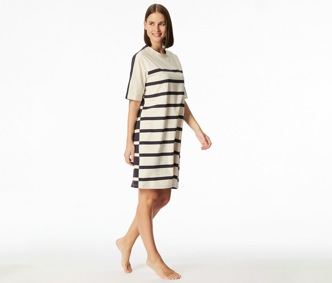 Mosolygó nő csíkos, rövid ujjú SCHIESSER hálóingben, ami térdig ér.