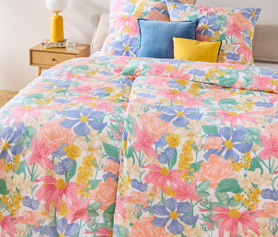Virágmintás Renforcé ágynemű, dupla, normál és extra méretben egy ágyon, kék és sárga párnákkal.