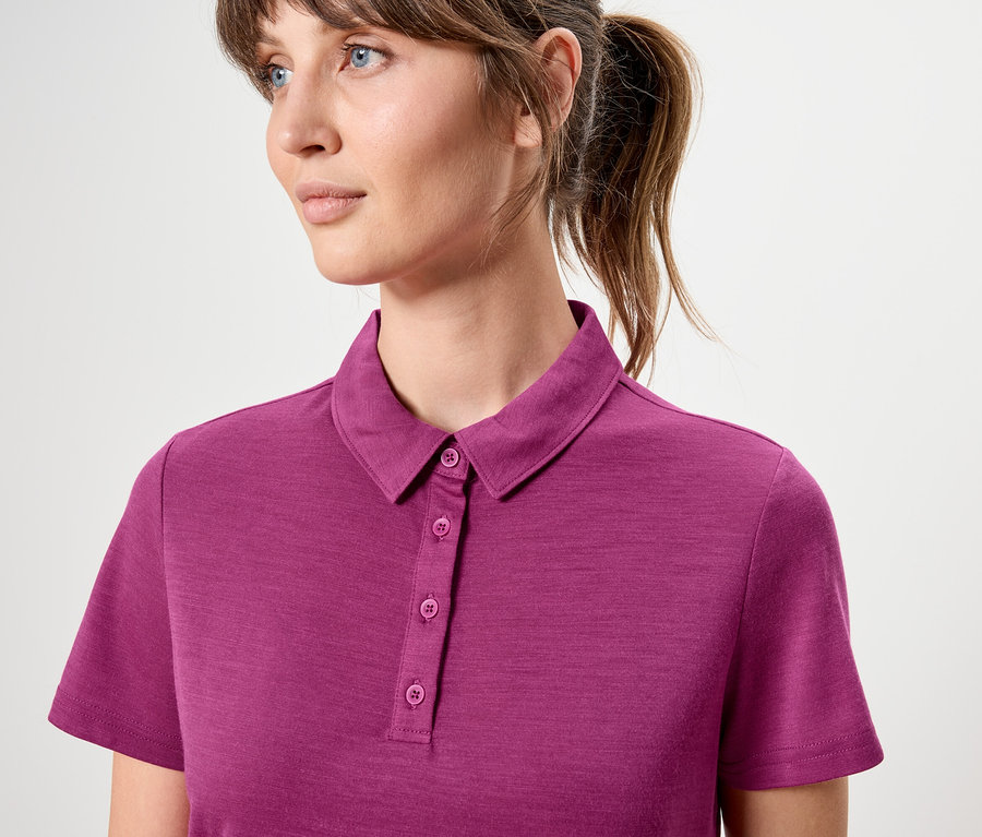 Nő visel rózsaszín, rövid ujjú pólót.