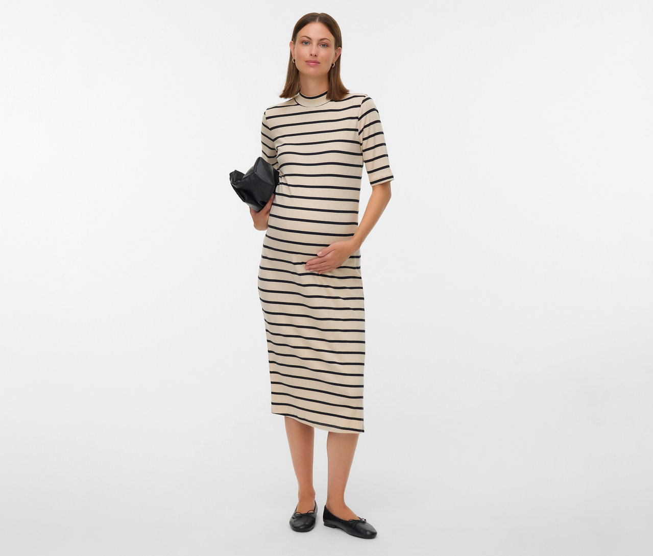 Csíkos MAMALICIOUS kismama midiruhát viselő nő fekete táskát tart és a hasát érinti.